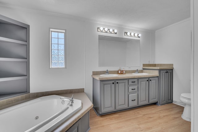 bathroom with ornamental molding, a textured ceiling, hardwood / wood-style floors, vanity, and toilet