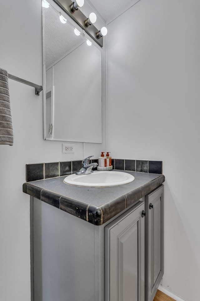 bathroom featuring vanity, a textured ceiling, and wood-type flooring