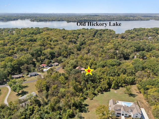 birds eye view of property with a water view and a view of trees