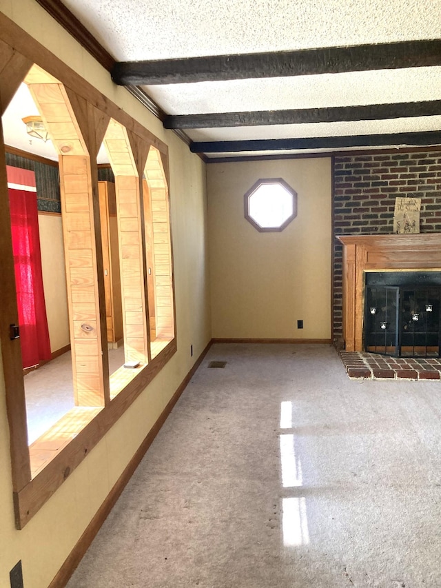 unfurnished living room featuring a brick fireplace, baseboards, visible vents, and beam ceiling