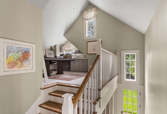 staircase with high vaulted ceiling