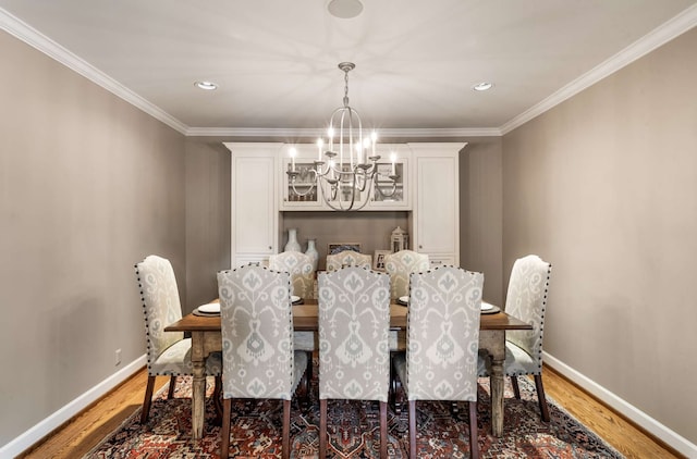 dining area featuring crown molding, dark hardwood / wood-style floors, and a notable chandelier