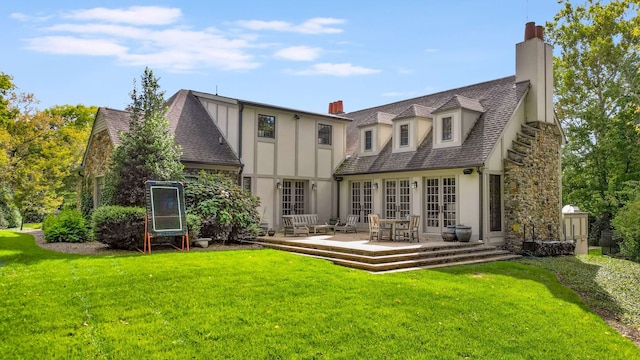 back of property featuring a lawn and a patio area