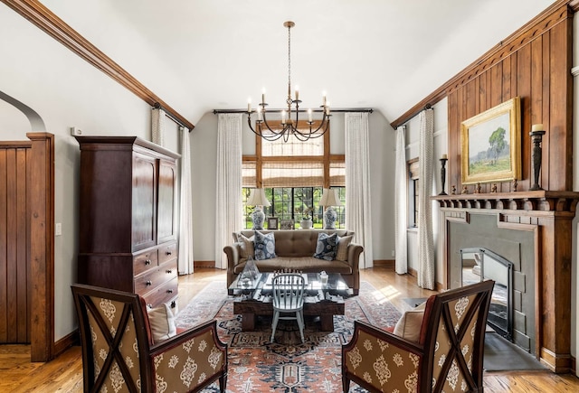 interior space featuring an inviting chandelier, light hardwood / wood-style floors, a tile fireplace, and crown molding