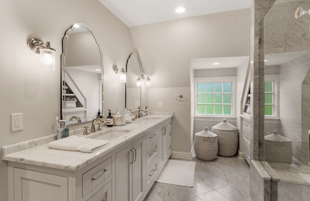 bathroom with a tile shower, lofted ceiling, and vanity