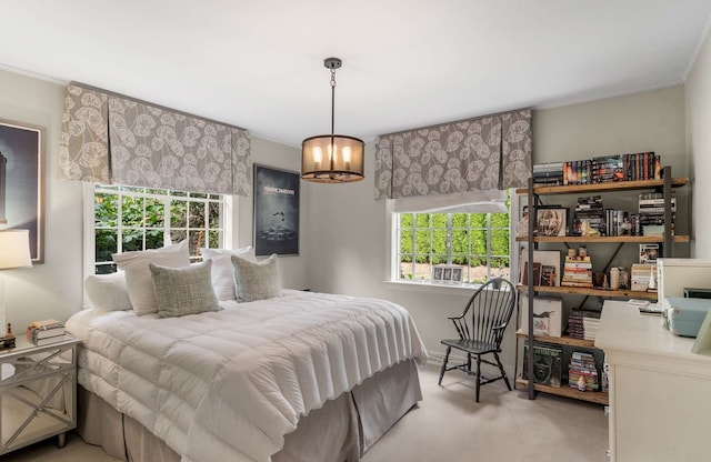 bedroom with a notable chandelier, ornamental molding, and carpet flooring