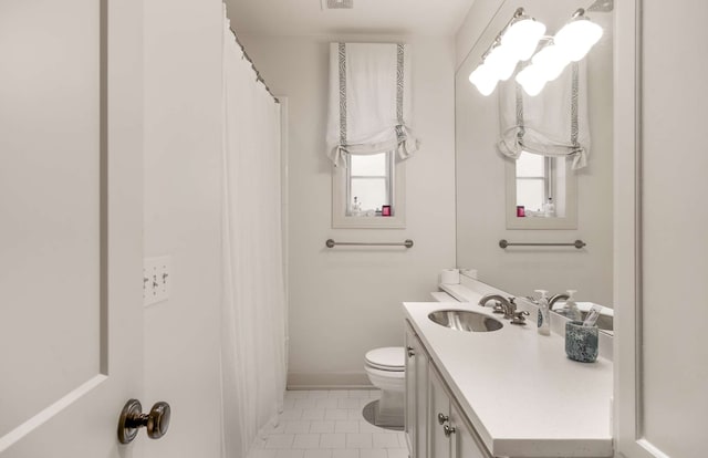 bathroom featuring a healthy amount of sunlight, tile patterned floors, vanity, and toilet