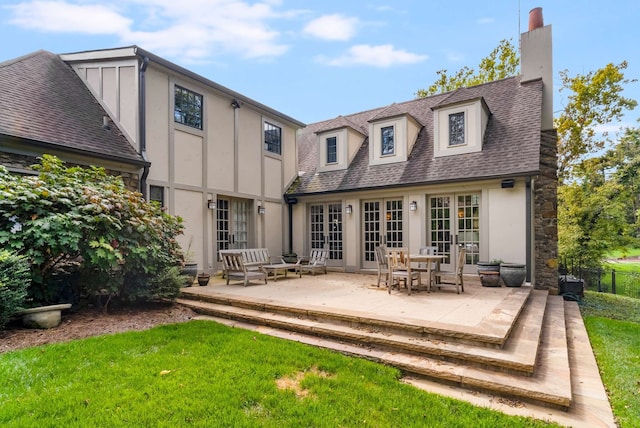 rear view of house with a patio, a yard, and french doors