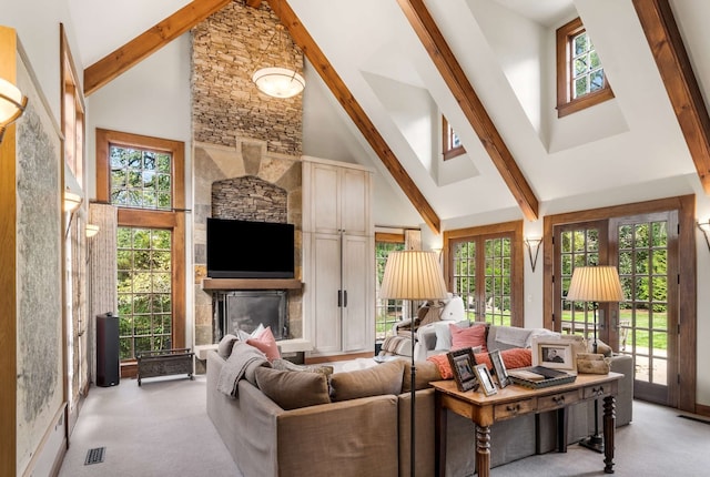 living room featuring a stone fireplace, beamed ceiling, light colored carpet, and high vaulted ceiling