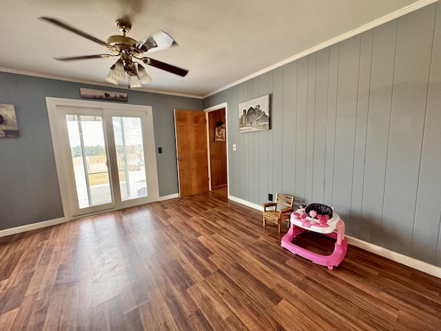 interior space featuring ornamental molding, wooden walls, ceiling fan, and hardwood / wood-style floors