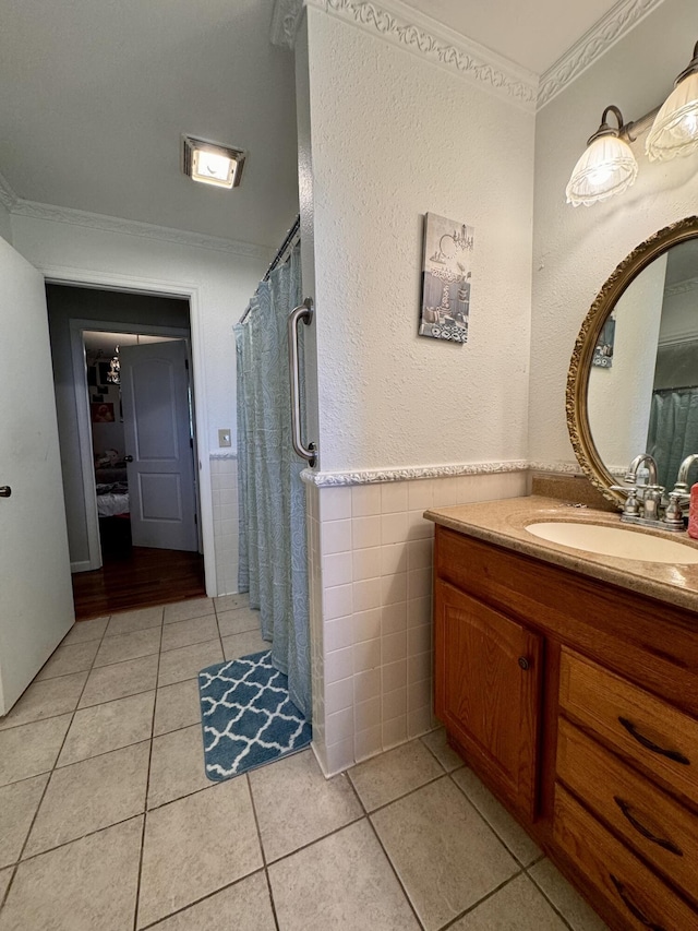 bathroom with ornamental molding, vanity, tile walls, and tile patterned floors