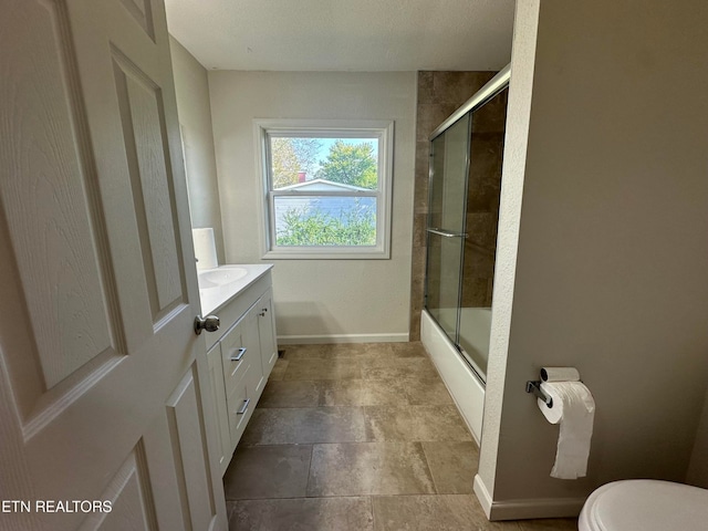 full bathroom featuring bath / shower combo with glass door, vanity, and toilet