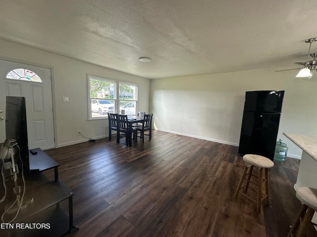 living room featuring a textured ceiling, dark hardwood / wood-style flooring, and ceiling fan