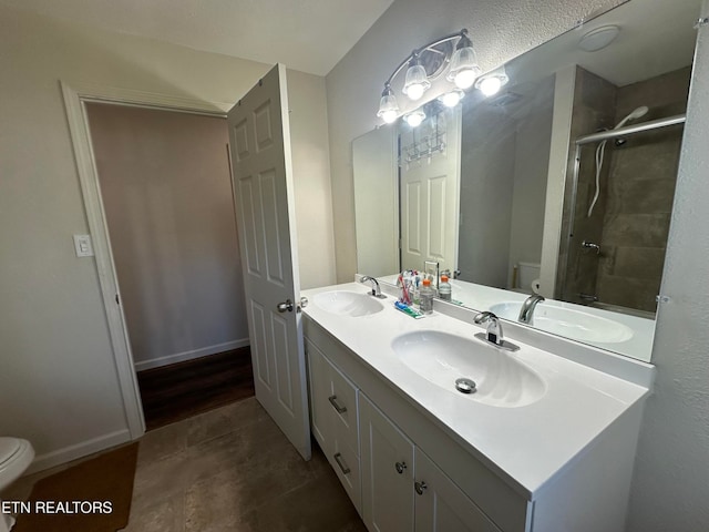 bathroom with wood-type flooring, vanity, toilet, and a shower with door