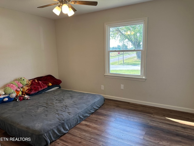 bedroom with ceiling fan and dark hardwood / wood-style flooring