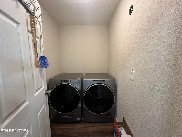 laundry area featuring a textured ceiling, dark hardwood / wood-style floors, and washing machine and clothes dryer