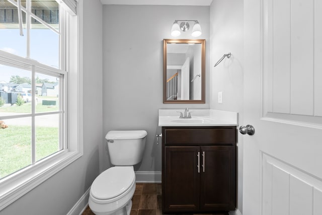 bathroom with a wealth of natural light, vanity, and toilet