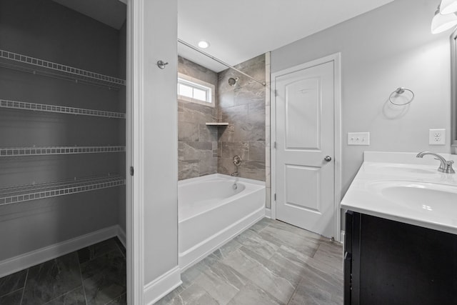 bathroom featuring tiled shower / bath combo and vanity