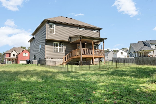 rear view of property with central air condition unit, a deck, and a yard