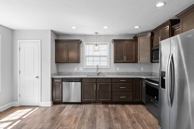 kitchen featuring pendant lighting, stainless steel appliances, dark hardwood / wood-style floors, and sink