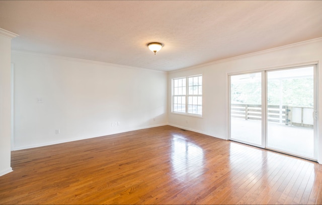 unfurnished room with hardwood / wood-style flooring, ornamental molding, and a textured ceiling