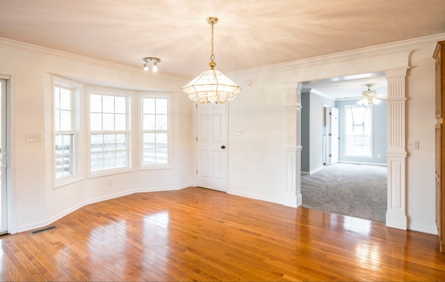 empty room featuring ceiling fan with notable chandelier, hardwood / wood-style floors, and crown molding