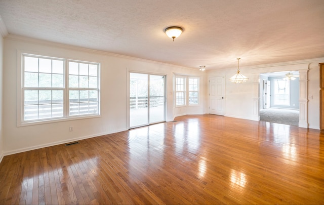 unfurnished living room featuring a textured ceiling, crown molding, ceiling fan with notable chandelier, and hardwood / wood-style floors