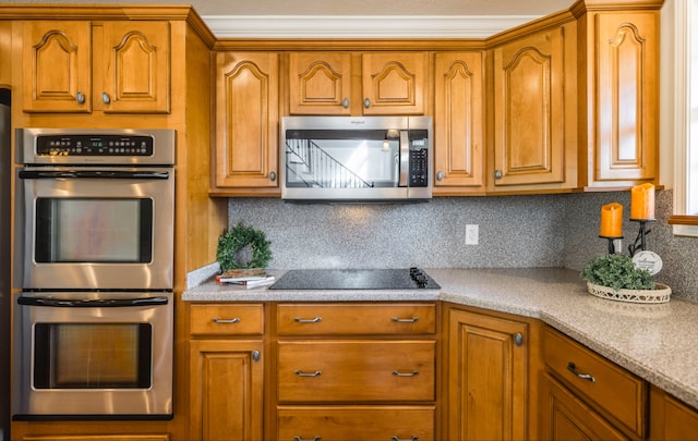 kitchen with light stone countertops, stainless steel appliances, and tasteful backsplash