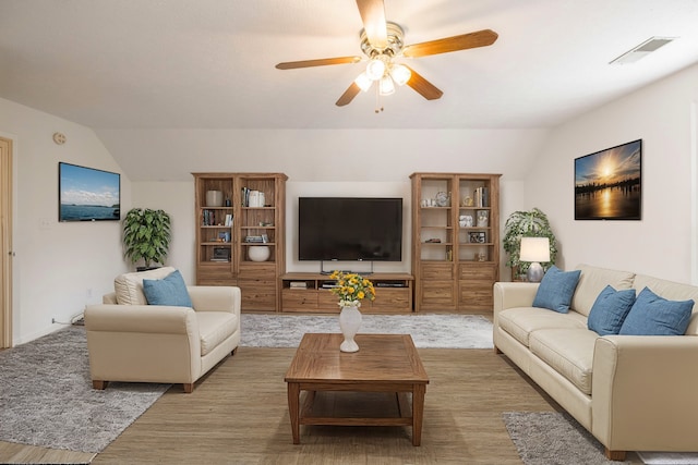 living room with wood-type flooring, vaulted ceiling, and ceiling fan