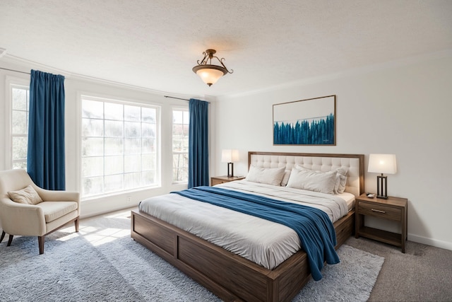 bedroom with a textured ceiling, ornamental molding, and light carpet