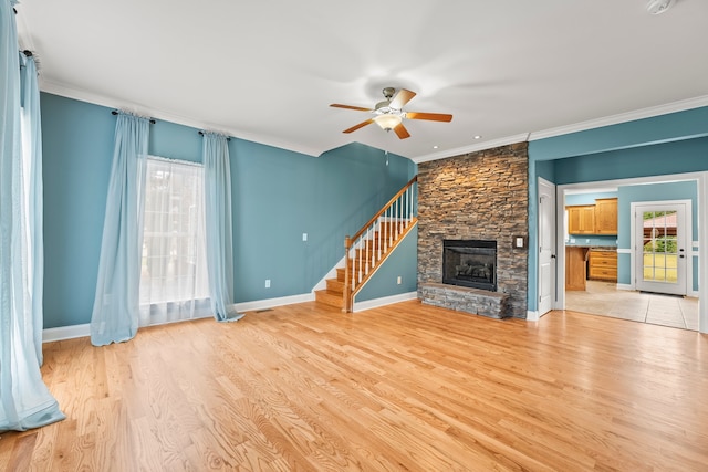 unfurnished living room featuring crown molding, light hardwood / wood-style floors, a fireplace, and ceiling fan