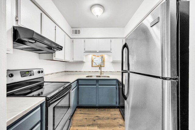 kitchen with sink, dark wood-type flooring, stainless steel appliances, and white cabinets