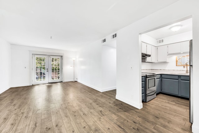 kitchen with gray cabinets, stainless steel appliances, light wood-type flooring, and sink