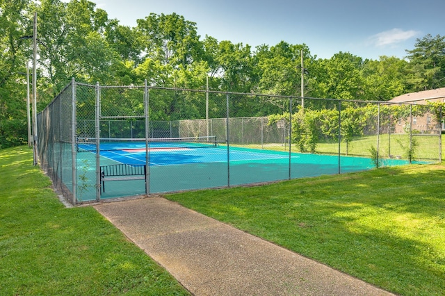 view of tennis court with a yard