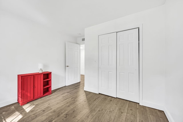 unfurnished bedroom featuring light wood-type flooring and a closet