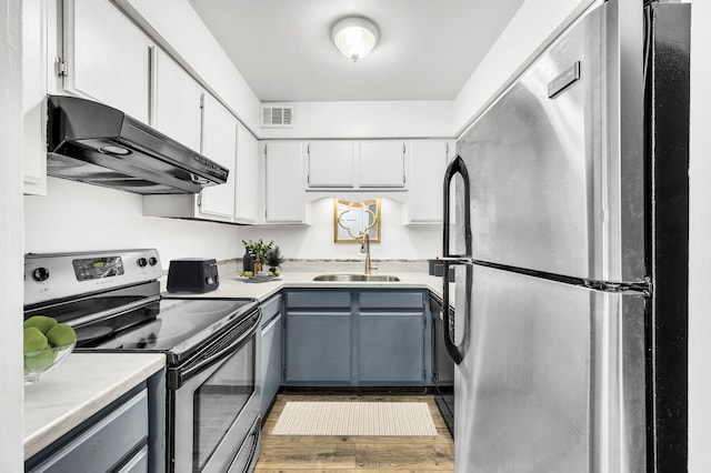 kitchen featuring wood-type flooring, gray cabinets, stainless steel appliances, and sink