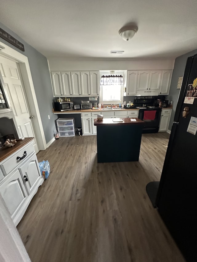 kitchen featuring black appliances, white cabinetry, and dark wood-type flooring