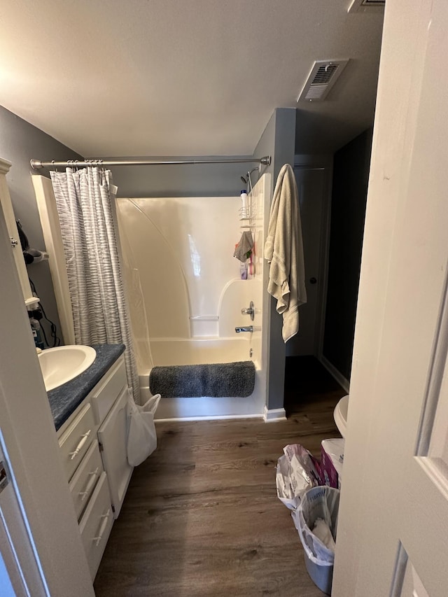 full bathroom featuring shower / bath combo with shower curtain, vanity, wood finished floors, and visible vents