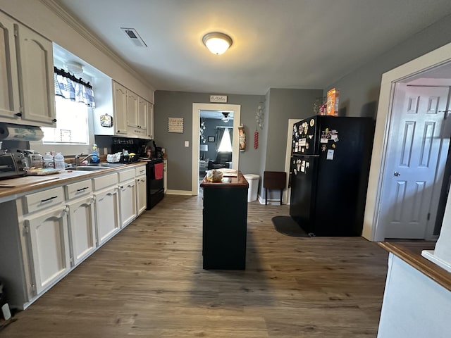kitchen featuring white cabinetry, wood finished floors, visible vents, black appliances, and ceiling fan