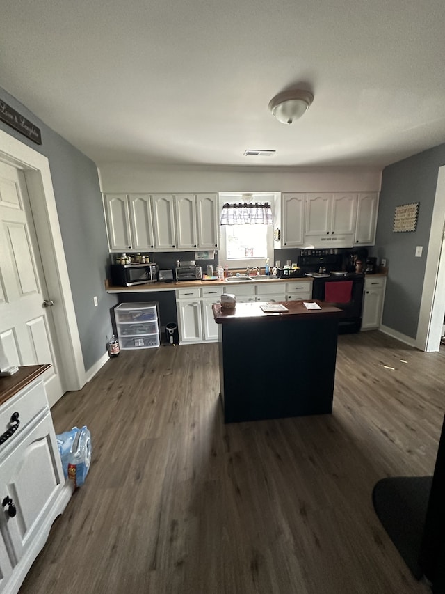 kitchen featuring dark hardwood / wood-style floors, black electric range oven, and white cabinetry