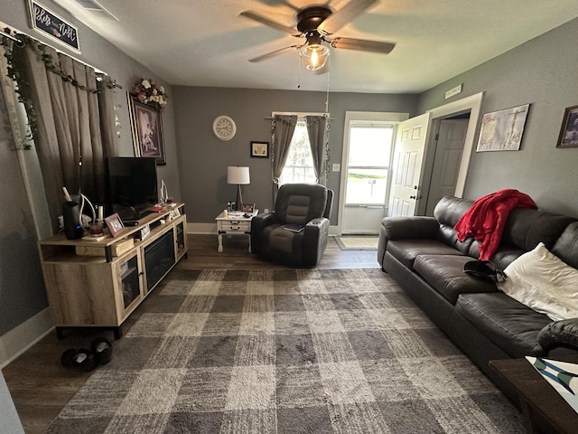 living area featuring a ceiling fan, dark wood-style flooring, baseboards, and visible vents