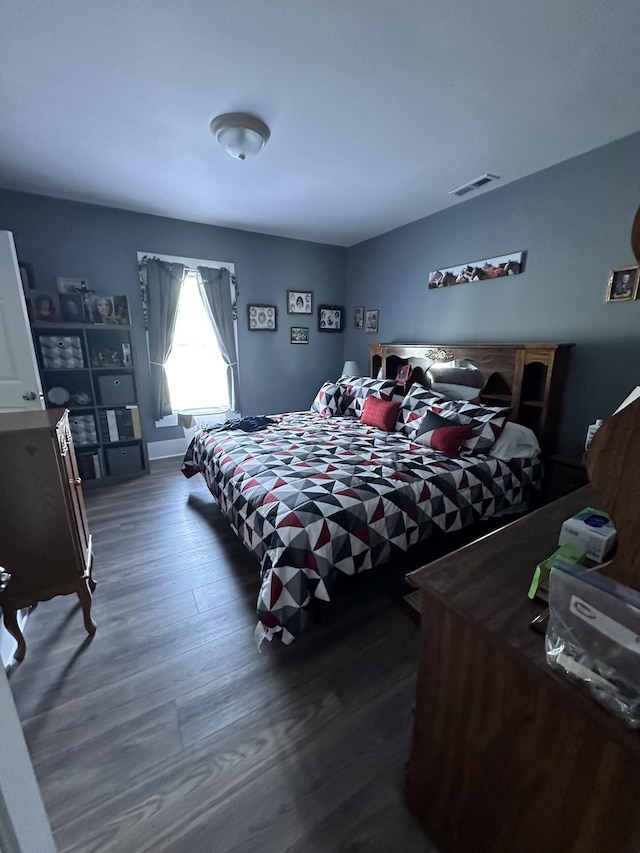 bedroom with dark wood-style floors and visible vents