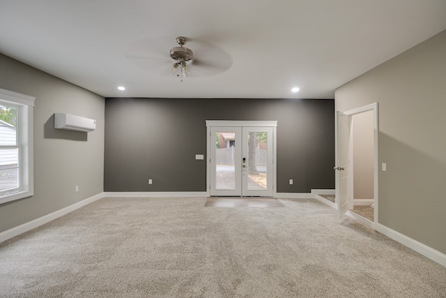 empty room with light carpet, french doors, ceiling fan, and a wall unit AC