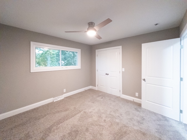 unfurnished bedroom with ceiling fan, a closet, and carpet flooring