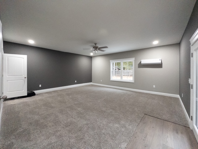 unfurnished room with an AC wall unit, ceiling fan, and carpet flooring