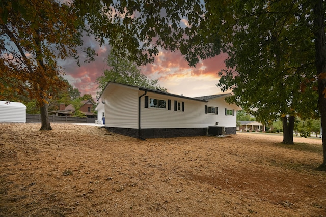 property exterior at dusk featuring cooling unit