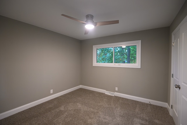 empty room featuring ceiling fan and carpet