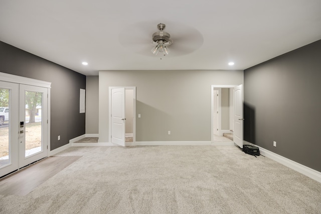 empty room featuring french doors, light colored carpet, and ceiling fan