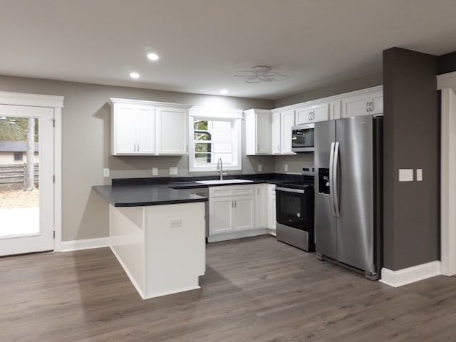 kitchen with white cabinets, appliances with stainless steel finishes, dark wood-type flooring, and sink