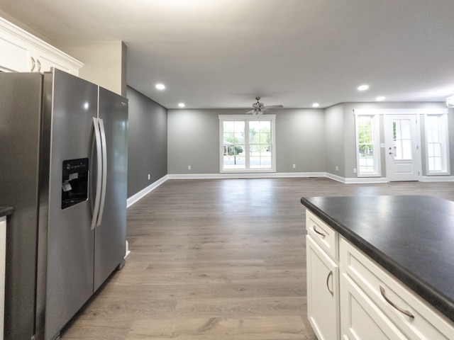 kitchen with ceiling fan, white cabinets, light wood-type flooring, and stainless steel fridge